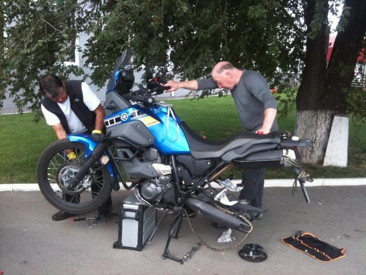 motorcycle rider repairing bike chain